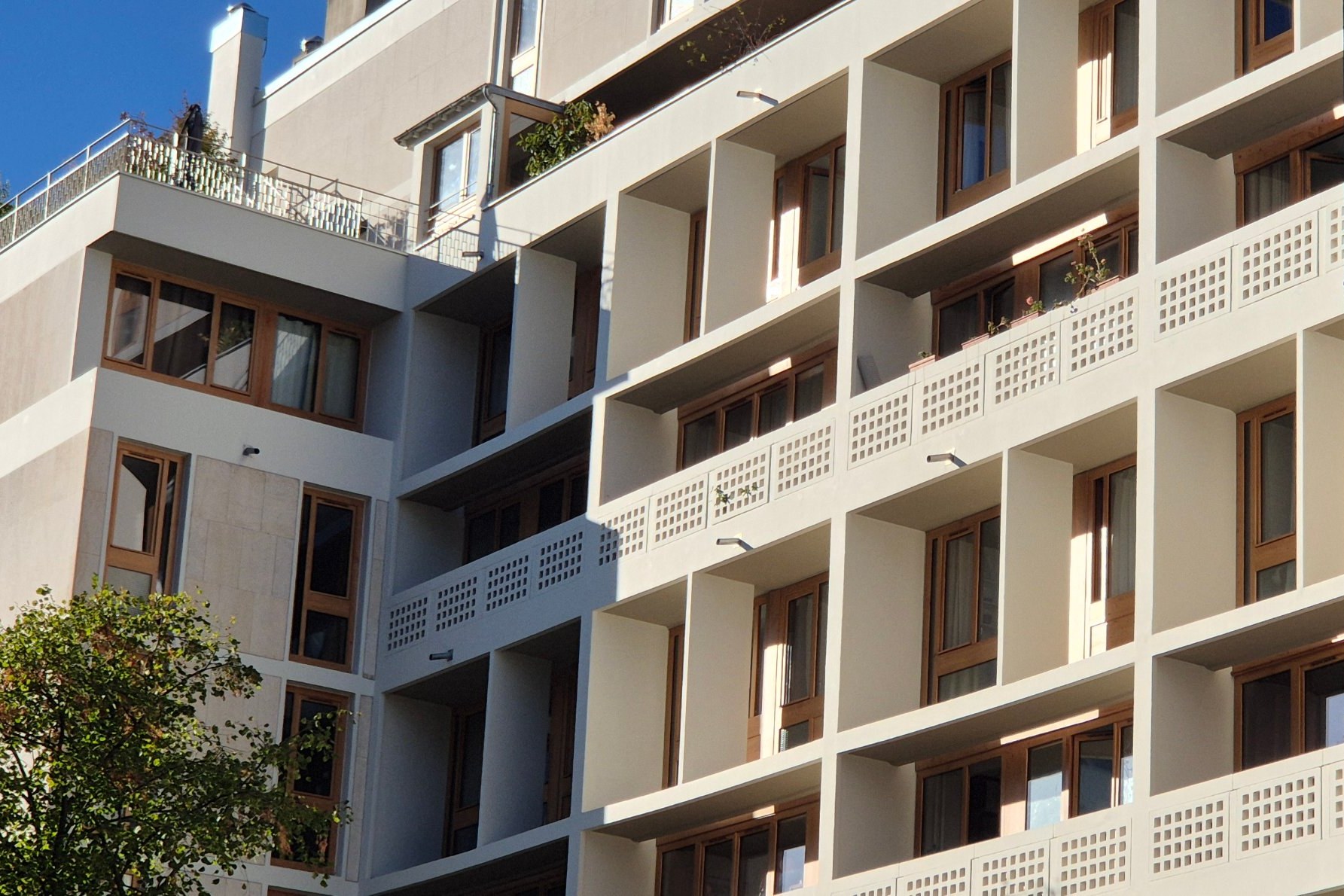 Façade d'un immeuble du 11e arrondissement : loggias, garde-corps ajourés et portes-fenêtres en bois neuves