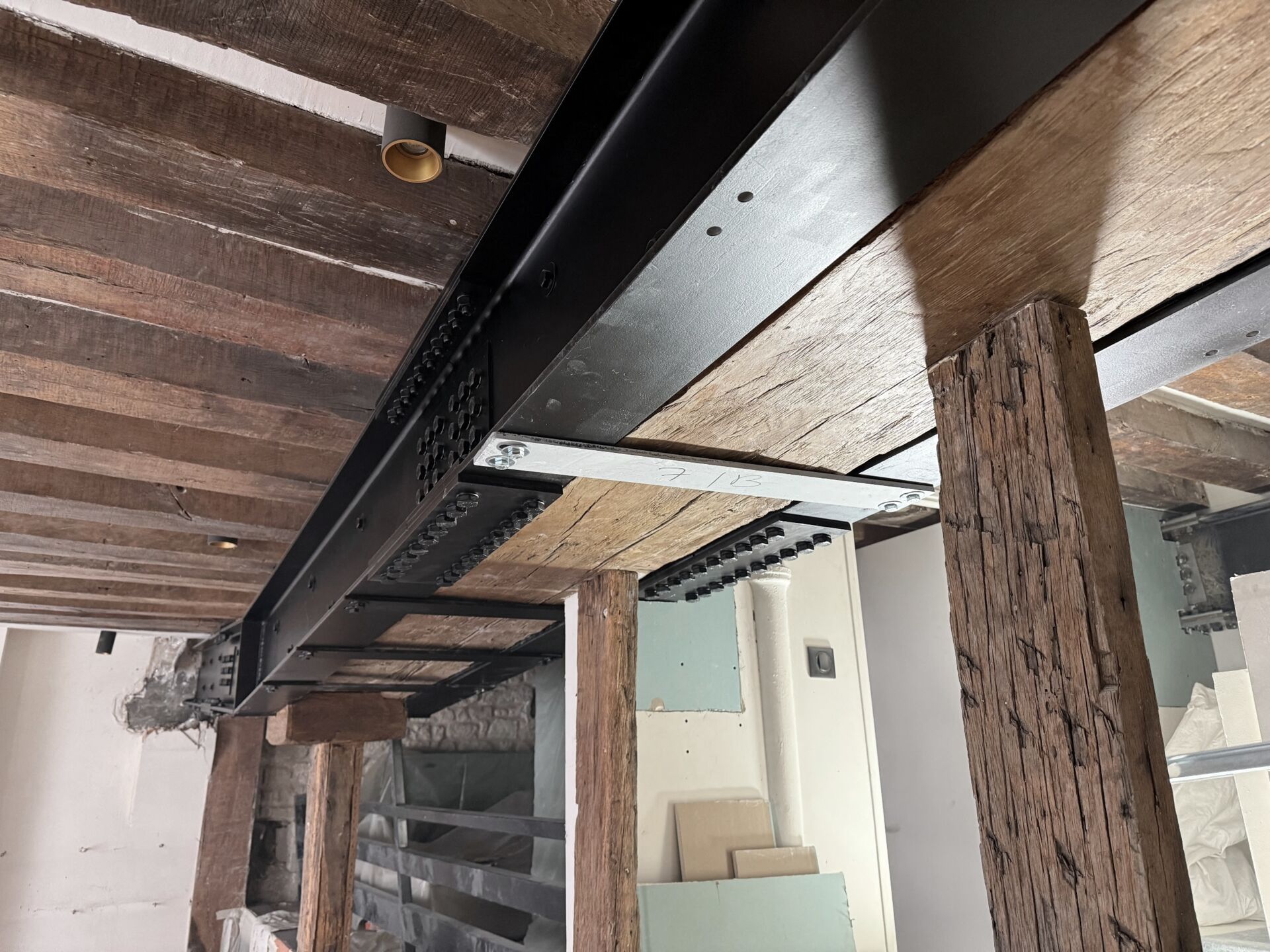 Plancher ancien renforcé par une poutre métallique, poteaux en bois